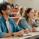 In the Classroom Multi Ethnic Students Listening to a Lecturer and Writing in Notebooks. Smart Young People Study at the College.