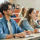 In the Classroom Multi Ethnic Students Listening to a Lecturer and Writing in Notebooks. Smart Young People Study at the College.